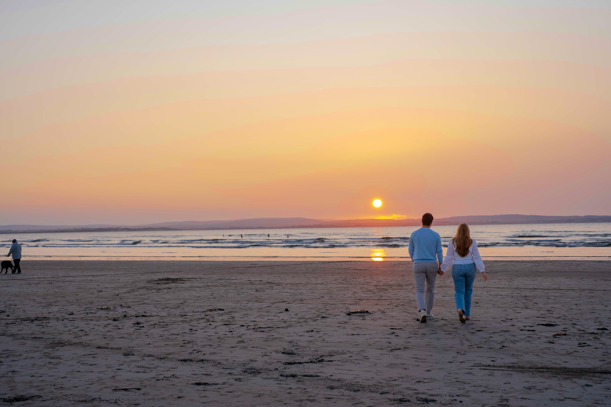 Laura and Andrew walking toward the sunset