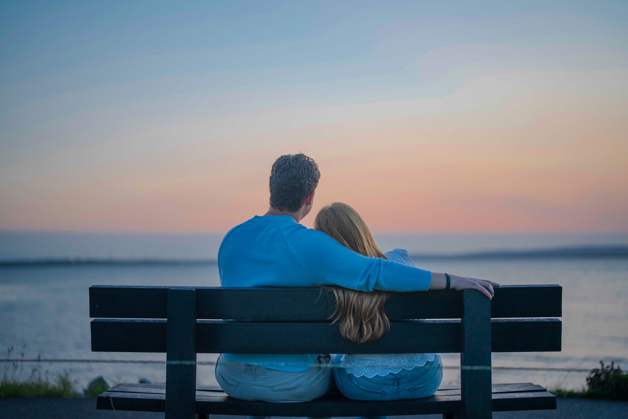 Laura and Andrew on a bench at sunset